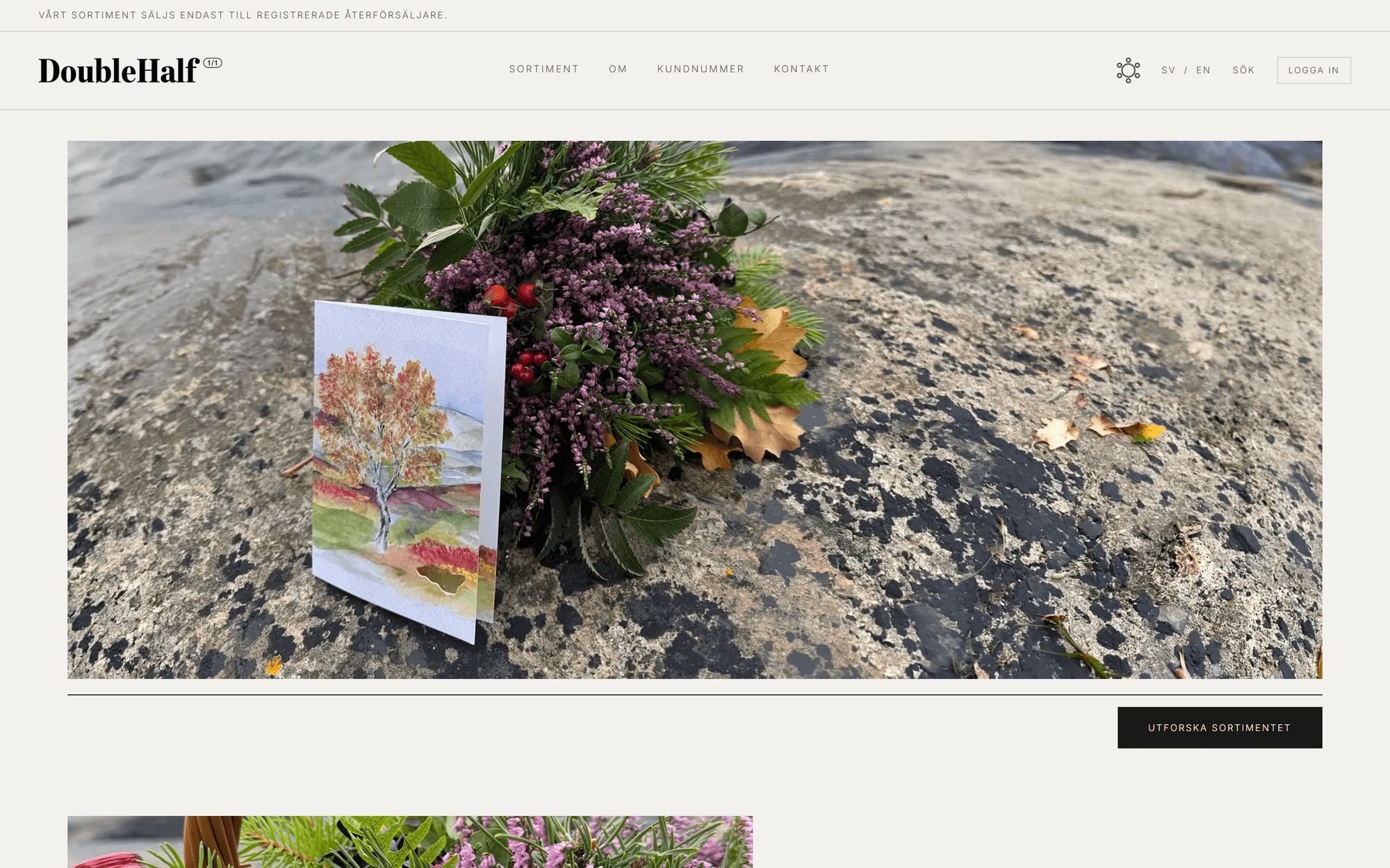 The Double Half start page. A banner says the range is sold only to registered resellers, and under the header is a large photo of a watercolour card of an autumn tree, with a small die-cut hole, leaning on a bouquet of heather and rosehips on a rock. A button under the photo reads Utforska sortimentet (Explore the catalogue).